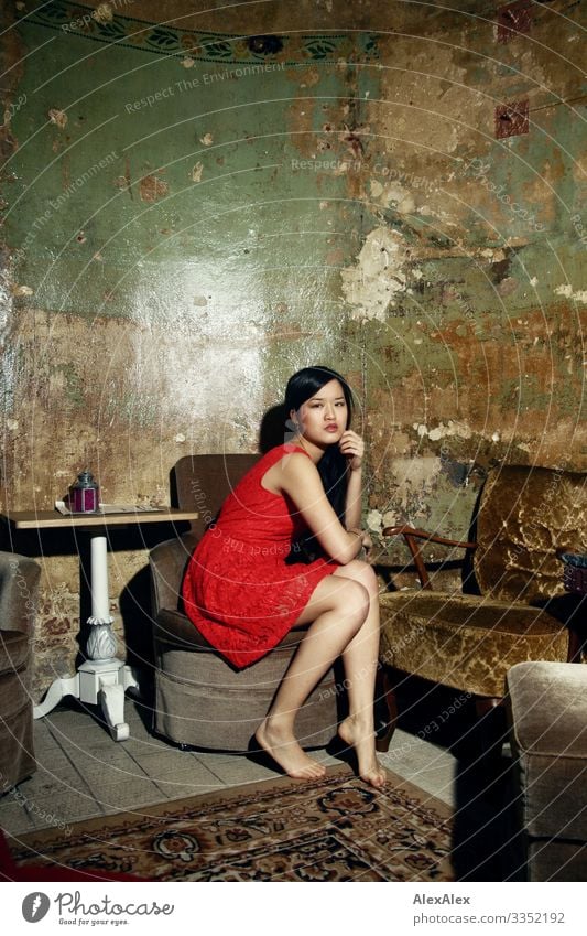 Young woman in red dress on an armchair Style Joy Beautiful Life Armchair Table Room Living room Youth (Young adults) Legs 18 - 30 years Adults Dress Barefoot