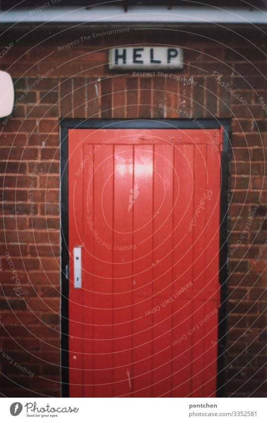 Sign with inscription Help above red door England Building Communicate Door Seeking help First Aid Brick Red Toilet Signs and labeling Mechanism Illuminate