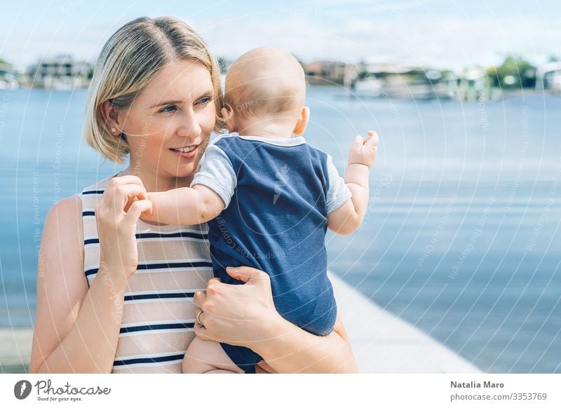 Mother holding baby son with a sea marina bay on background Joy Happy Beautiful Face Life Summer Beach Ocean Parenting Child Baby Toddler Woman Adults Parents