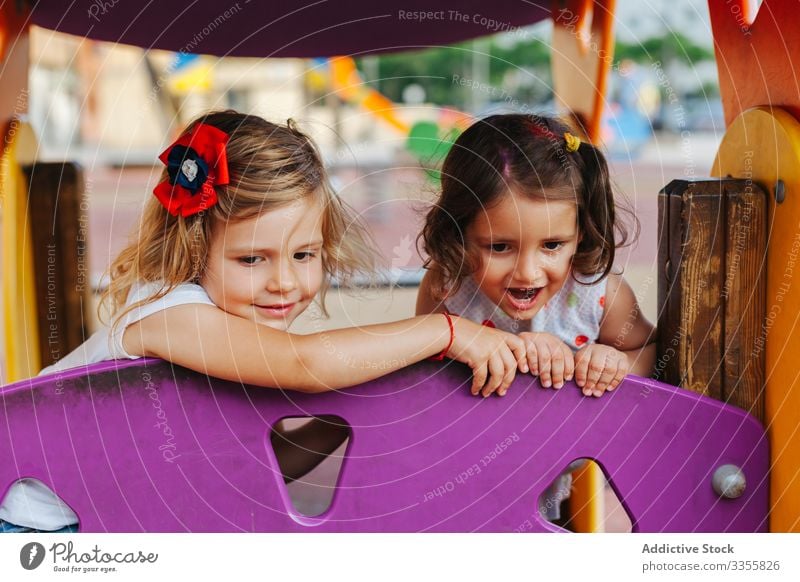 Funny girls playing on playground friend together railing peek out weekend fun rest kid child friendship childhood relax lifestyle curious imagination fantasy