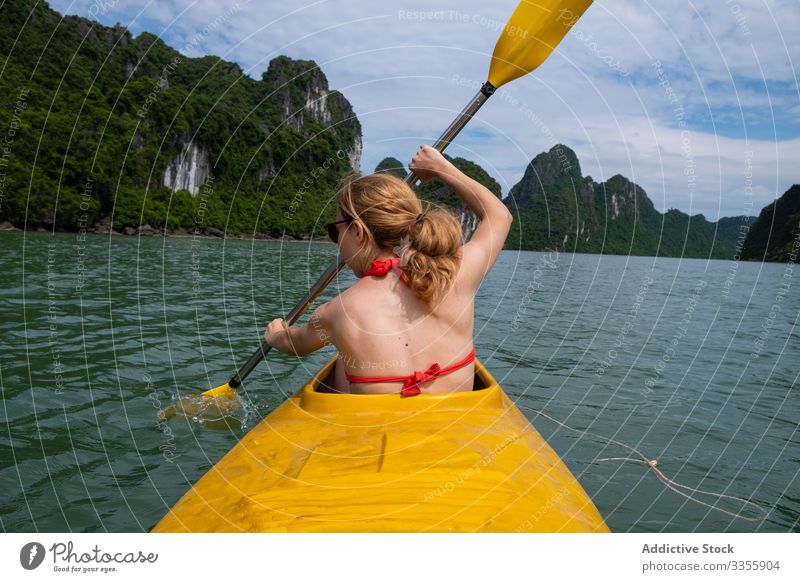 Faceless female tourist rowing in canoe woman paddle vacation water travel boat tourism asia nature vietnam sea blue kayaking active summer adventure sport