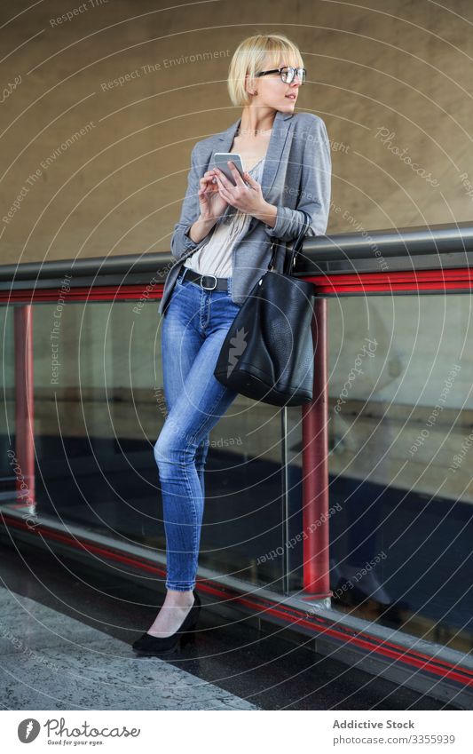 Businesswoman with smartphone businesswoman stylish young mobile connection cheerful handrail leaning female professional person beautiful using browsing