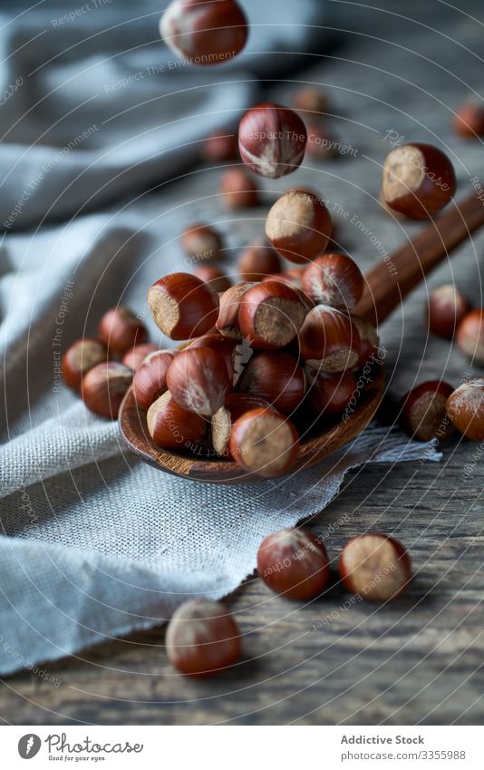 Brown ripe hazelnut on spoon at table brown healthy edible wooden filbert gathering heap ingredient natural harvest organic raw seed food snack linen tasty