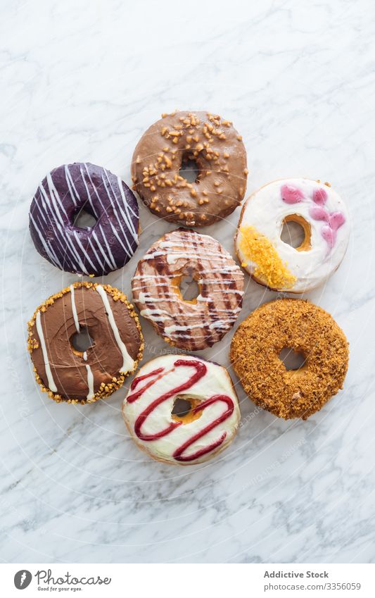 Variety of doughnuts on marble background variety assortment sweet icing glazed food donut sugar bakery pastry sprinkle fried colorful many dessert delicious