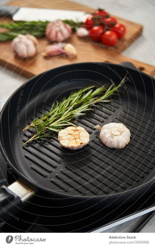 Grill pan with rosemary and garlic in kitchen grill seasoning herb cooking food aromatic frying meal flavour ingredient product cuisine roast cut sprig recipe
