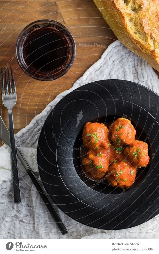 Delightful meatballs served on rustic table tomato sauce bread beverage cutlery plate delicious food meal homemade gourmet dinner lunch cuisine dish recipe