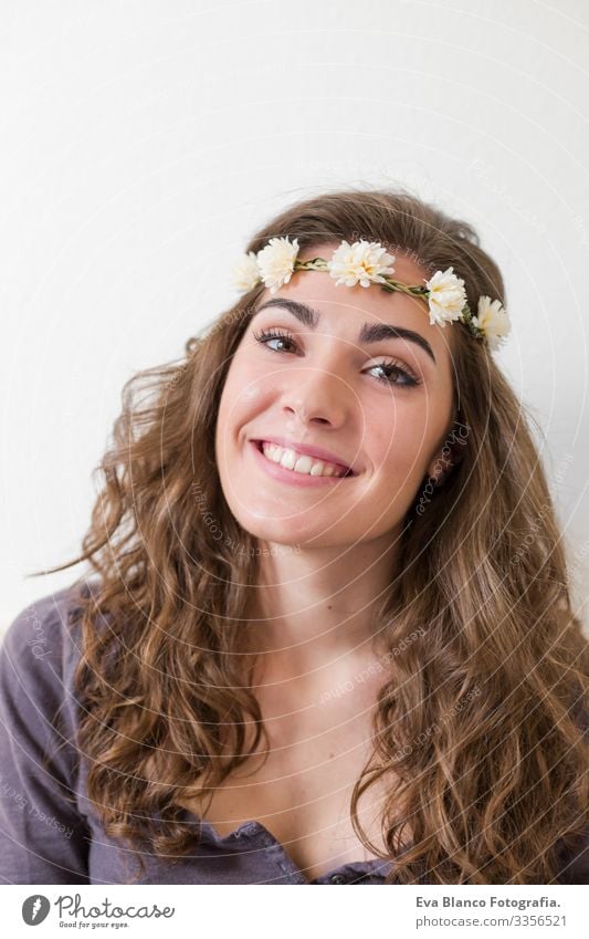 portrait of a young beautiful woman wearing a flowers wreath. She is smiling, indoors. Lifestyle. Vertical view. Head Elegant Amazing Aromatic Considerate