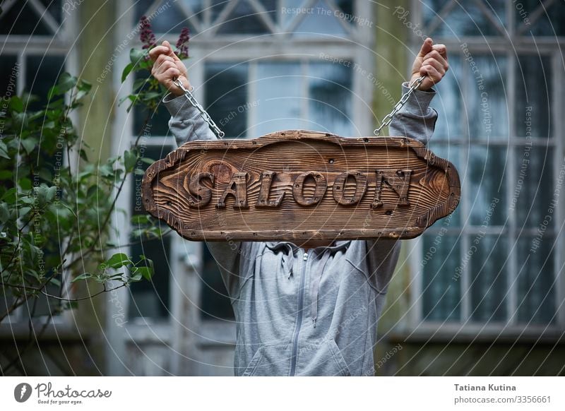 Man's hands holds an signboard with the words "Salon". Alcoholic drinks Shopping Vacation & Travel Tourism House (Residential Structure) Business Town Building
