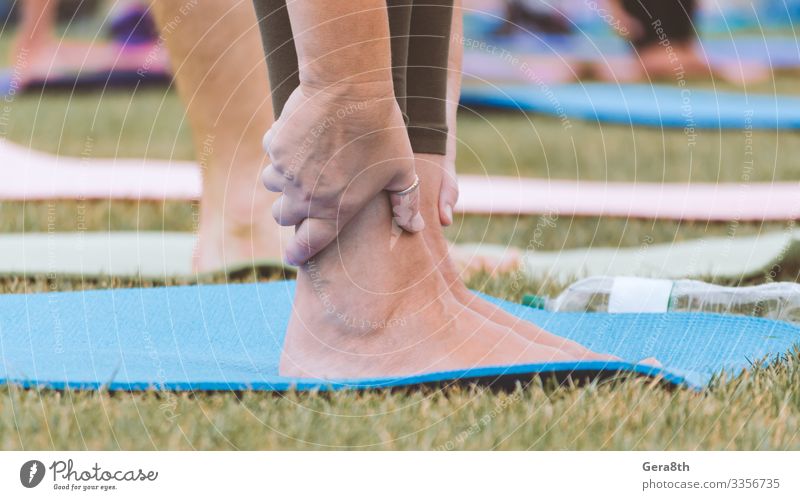 female legs on yoga mat close up Bottle Skin Summer Sports Yoga Woman Adults Hand Fingers Group Nature Grass Park Street Railroad Fresh Green Colour Action