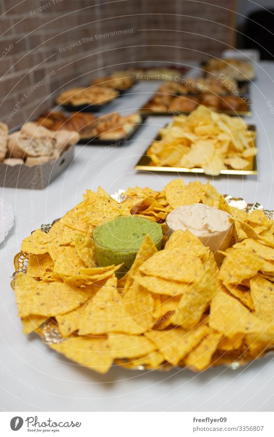 Table of appetizers with mexican nachos lunch white party counter table buffet holiday decoration food line service anniversary banquet dining eat dish desert