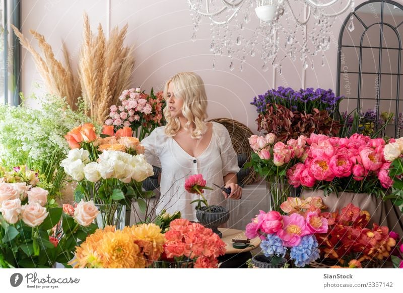 Beautiful blonde florist woman creates a wonderful bouquet Human being Woman Adults 1 18 - 30 years Youth (Young adults) 30 - 45 years Spring Plant Flower Rose