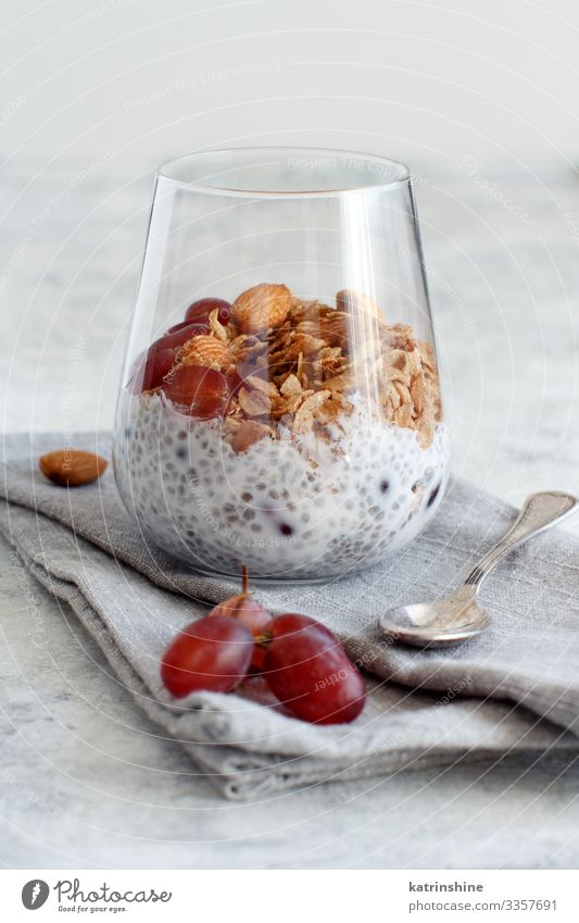 Chia pudding parfait with red grapes and almonds Yoghurt Fruit Dessert Eating Breakfast Diet Spoon Gray White jar chia Bunch of grapes nuts Pudding seed
