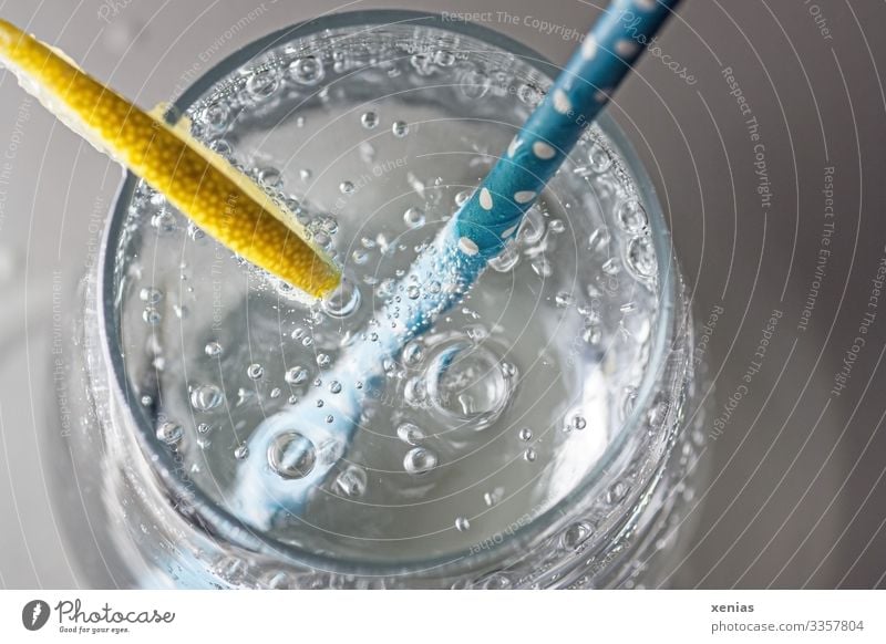 Sparkling mineral water with lemon and blue drinking straw in a glass from above Drinking water Lemon Beverage Cold drink Glass Water Straw Healthy