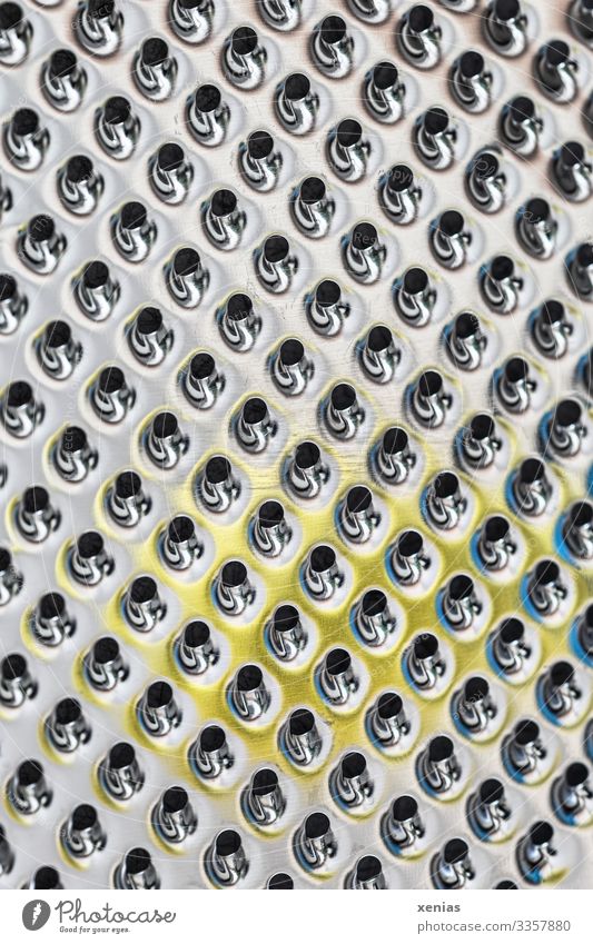 Macro shot of a kitchen grater with yellow spot of precious metal Grater Cooking Metal Glittering Round Clean Yellow Black Silver Futurism Hollow Row Patch