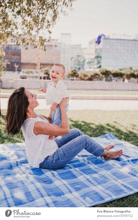young mother playing with baby girl outdoors in a park, happy family concept. love mother daughter Child Parenting Girl Joy Sunbeam Parents Mother Spring Baby