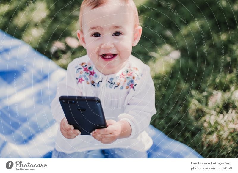 happy baby using mobile phone outdoors. technology concept Mother Baby Cellphone Technology Together Child Parenting Girl Joy Sunbeam Parents Spring parenthood