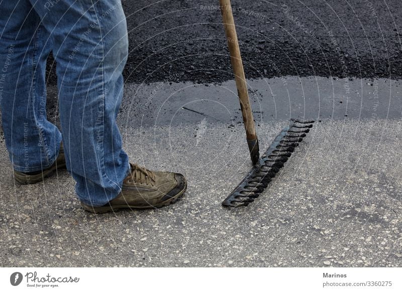 Workers using asphalt tools during road construction. Work and employment Industry Tool Man Adults Building Transport Street Black equipment roller roadwork