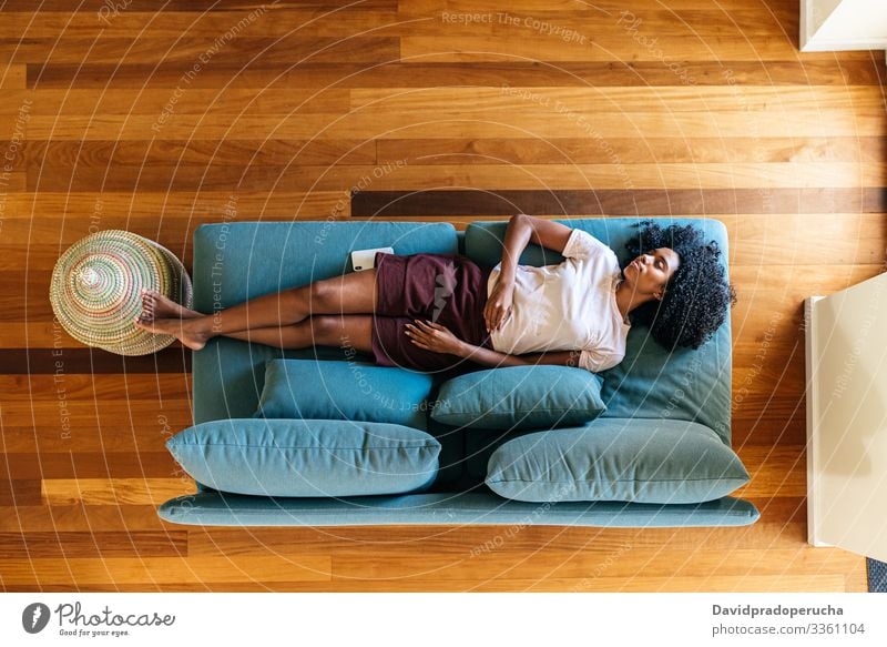 Young black lady sleeping on sofa at home woman day nap living room lying armchair modern casual african american female relax rest tranquil lifestyle tired