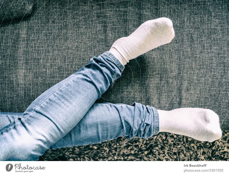 Woman lies comfortably on the sofa from above only the legs Contentment Relaxation Sofa Living room Feminine Adults Life Legs 1 Human being 30 - 45 years Jeans