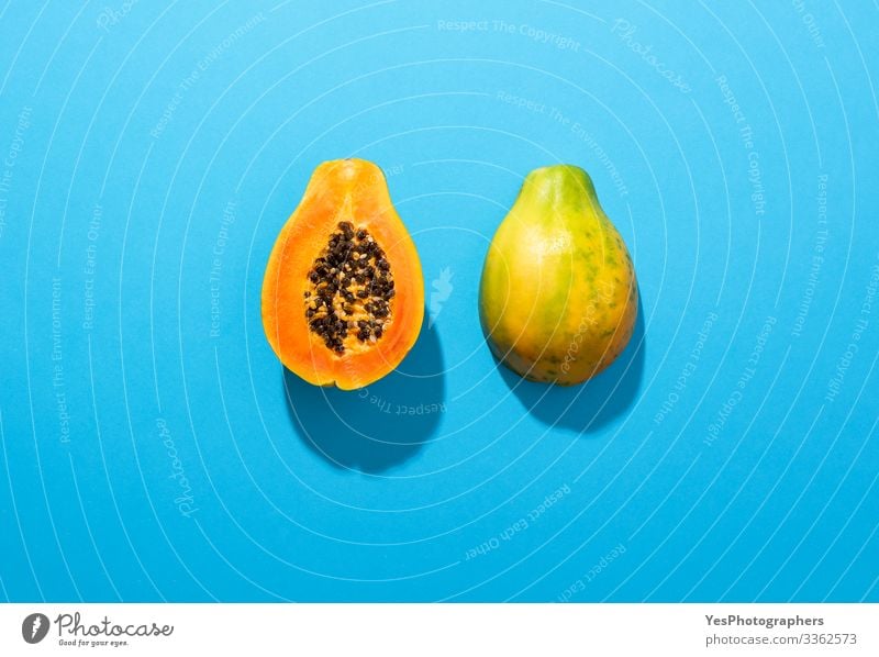 Ripe papaya fruit cut in half on blue background Food Fruit Dessert Nutrition Organic produce Healthy Eating Fragrance above view Blue background colorful