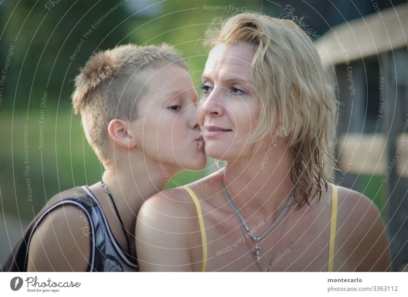 Son kisses his mother on the cheek Family Young woman Trust Contentment Safety Safety (feeling of) Loyal Protection Love Calm Colour photo Authentic Day