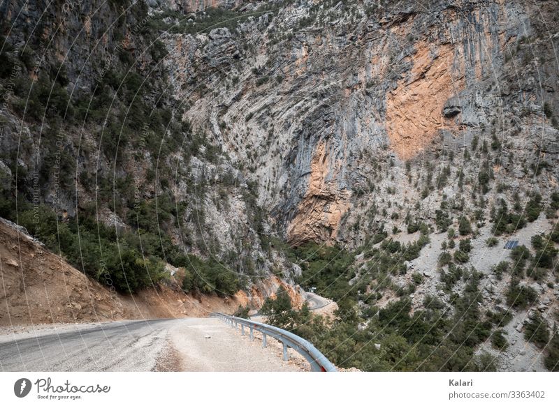 Winding road in the mountains leads to a rock face Street Wall of rock Trip route off Landscape Sparse panorama Nature Sky Turkey Blue arrive Summer Desert view