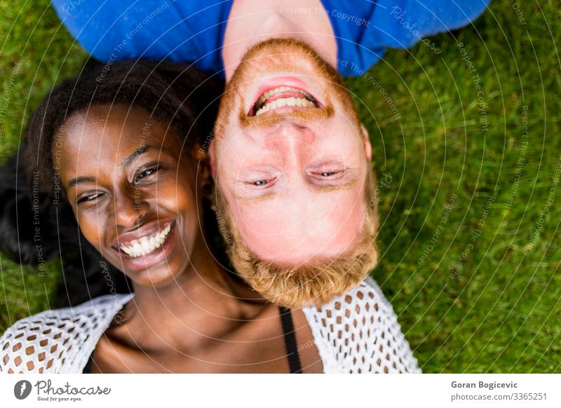 Multiracial couple in the park Lifestyle Summer Human being Young woman Youth (Young adults) Young man Woman Adults Man Couple 2 18 - 30 years Grass Red-haired