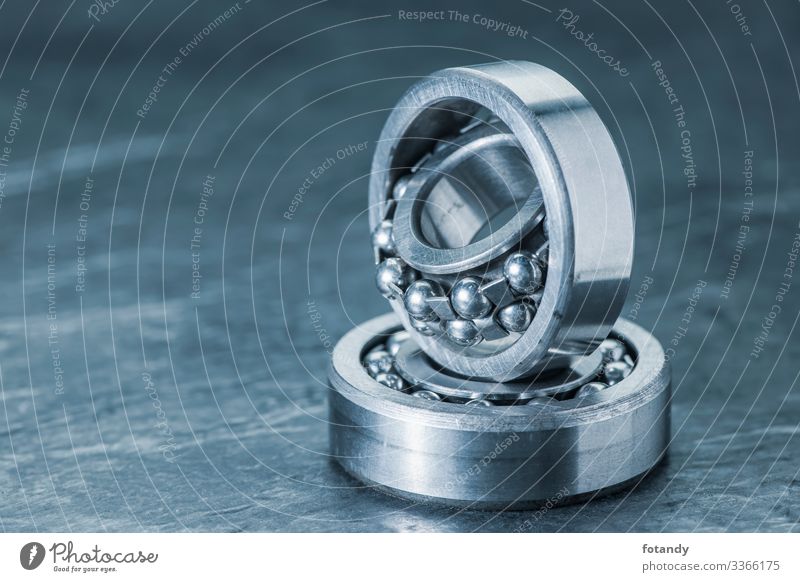 Two spherical roller bearings on slate blue toned Industry Craft (trade) Technology Metal Steel Sphere Rotate Stand Exceptional Round Blue Gray Movement