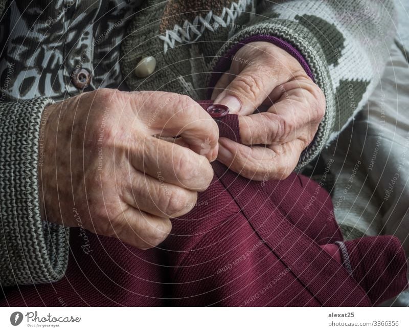 Older woman's hands sewing a button Leisure and hobbies Craft (trade) Woman Adults Grandmother Hand Age background Buttons close Embroidery grandma granny