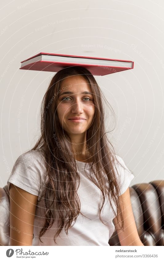 Portrait of Young Woman with Book on Head book female girl woman young adult youth culture day urban female beauty beautiful woman natural beauty