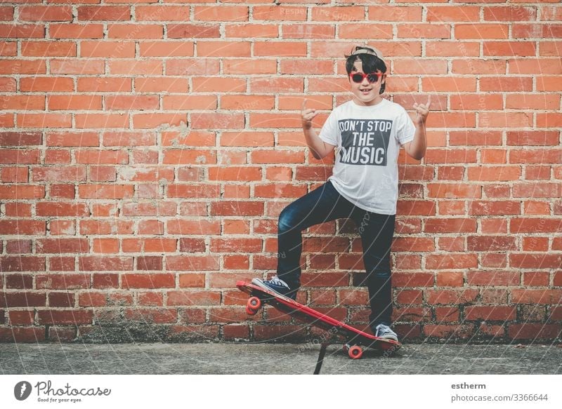 child with a skateboard and sunglasses doing rock symbol with hands up Lifestyle Joy Leisure and hobbies Freedom Summer Music Sports Fitness Sports Training