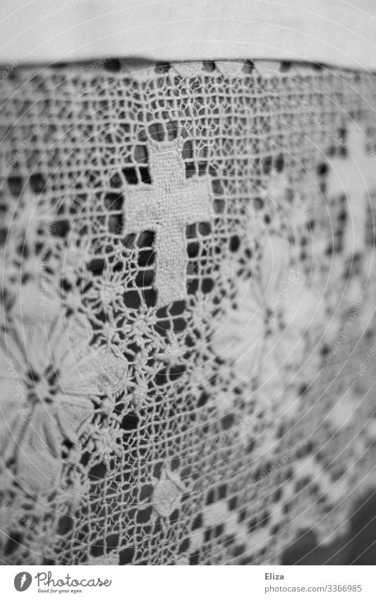 A white crocheted blanket with flowers and crucifix/cross ornaments and patterns in the church Crocheted decorative blanket doily Pattern Ornament Church
