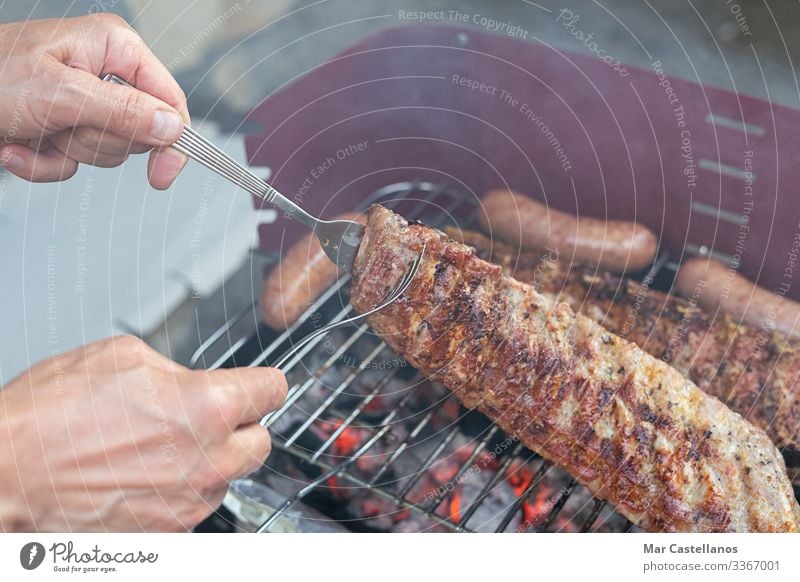 Hands turning pork chops on the grill. Concept of food. Meat Fork Restaurant Feasts & Celebrations Work and employment Human being Family & Relations Friendship