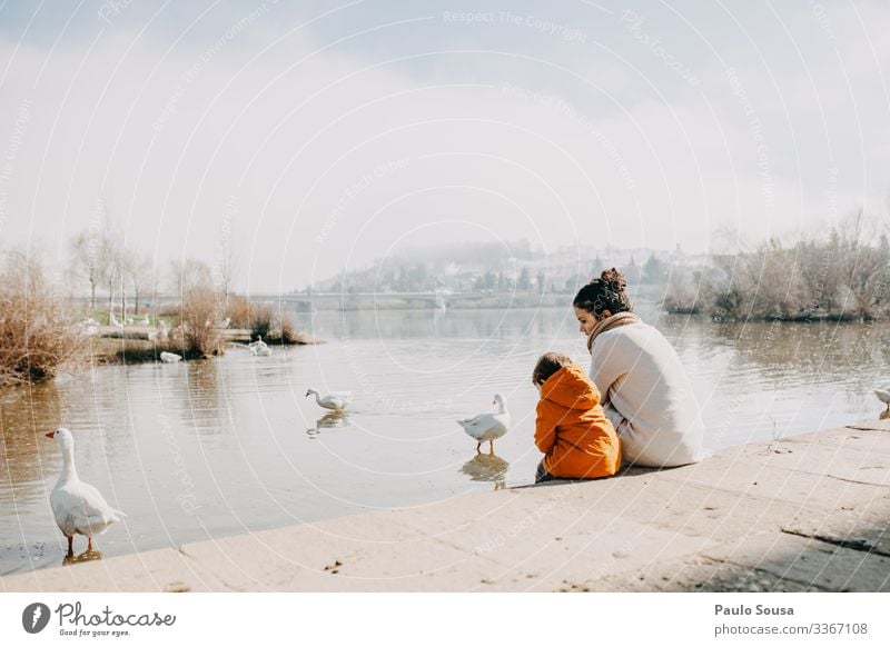Mother and Daughter watching ducks by the river Lifestyle Leisure and hobbies Vacation & Travel Tourism Human being Feminine Toddler Girl Parents Adults 2