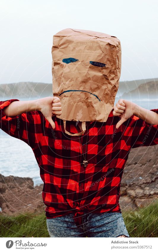 Person with paper bag on head showing thumb down package ecology concept disapproval dislike disagree environment person gesture sign nature pollution problem