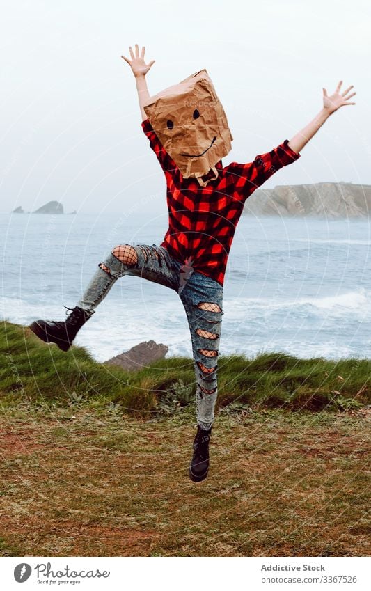 Person with paper bag on head jumping on shore plastic package ecology concept environment person gesture sign nature pollution problem packet polyethylene