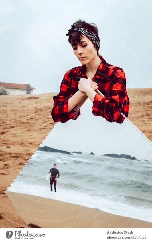 Sad woman with big mirror standing on beach concept reflection sea serious sad surfer couple pensive stormy casual young female ocean sand water thoughtful
