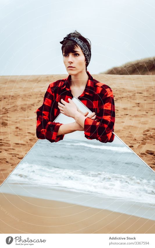 Lonely thoughtful woman with large mirror standing on beach concept reflection sea lonely sad stormy pensive casual young female ocean sand empty water think