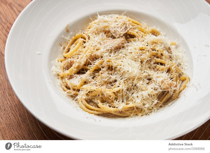 Portion of pasta with Parmesan spaghetti traditional culinary cheese dish food plate restaurant parmesan meal wooden table classic italian dinner lunch fresh
