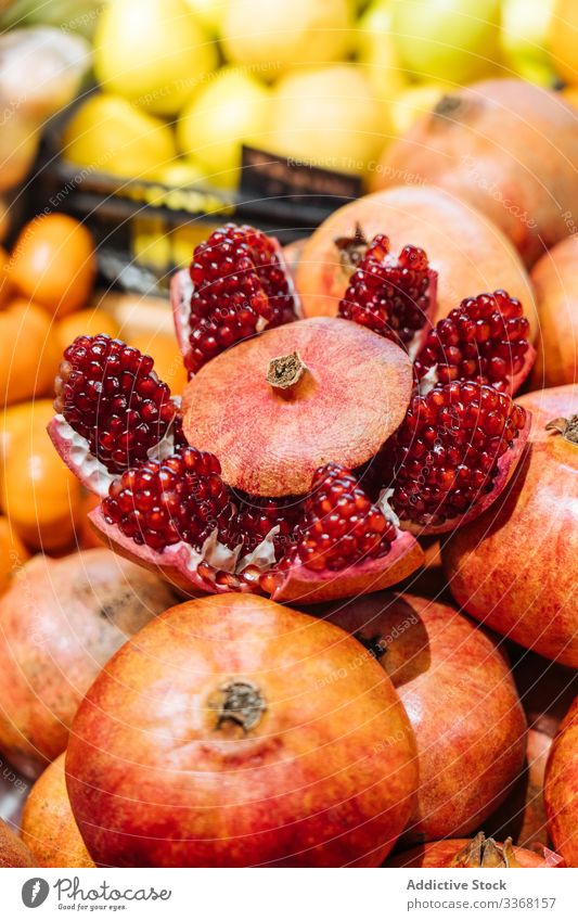 Sliced ripe pomegranate in shop fruit store fresh grocery cut seed juicy stall heap commerce pile piece slice food market bazaar sell raw fiber product vitamin