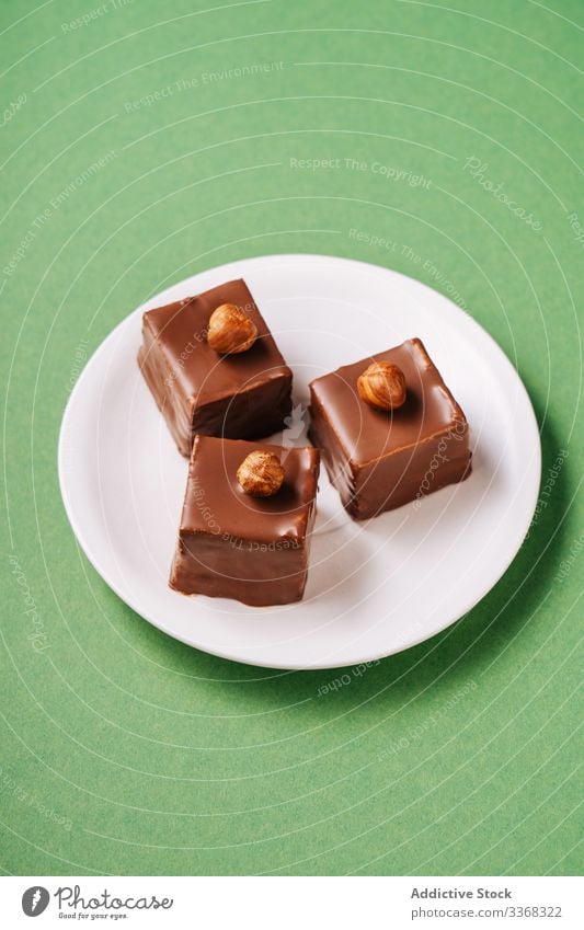 Chocolate dessert with hazelnuts on plate chocolate icing sweet food pastry tasty cuisine dish delicious yummy scrumptious sugar calorie portion piece baked