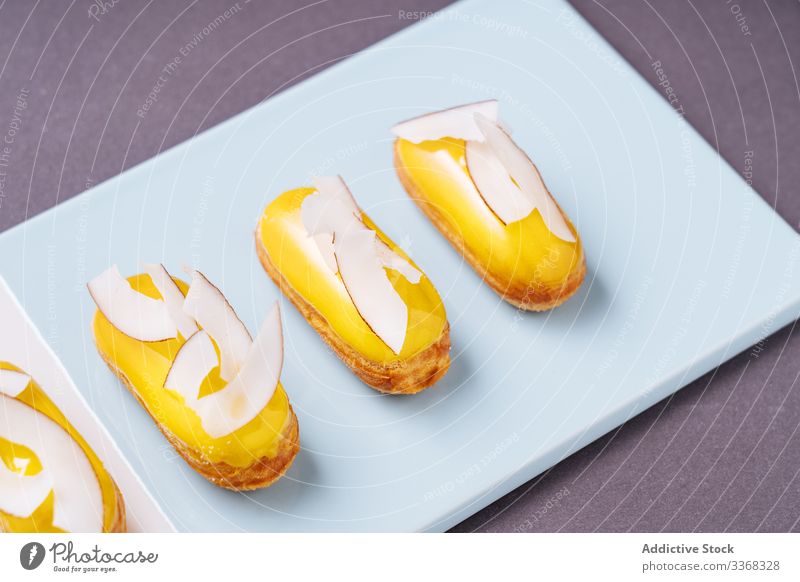 Yummy eclairs with coconut dessert fruit banana icing sweet board food pastry tasty cuisine dish delicious yummy scrumptious sugar calorie portion piece soft