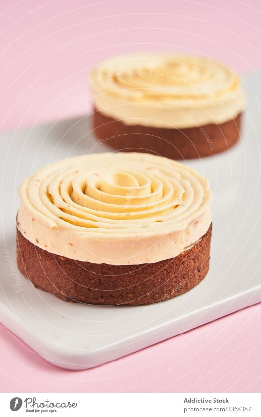 Yummy desserts with cream spiral sweet decor food pastry board tasty cuisine dish delicious yummy scrumptious sugar calorie portion piece baked gourmet prepared