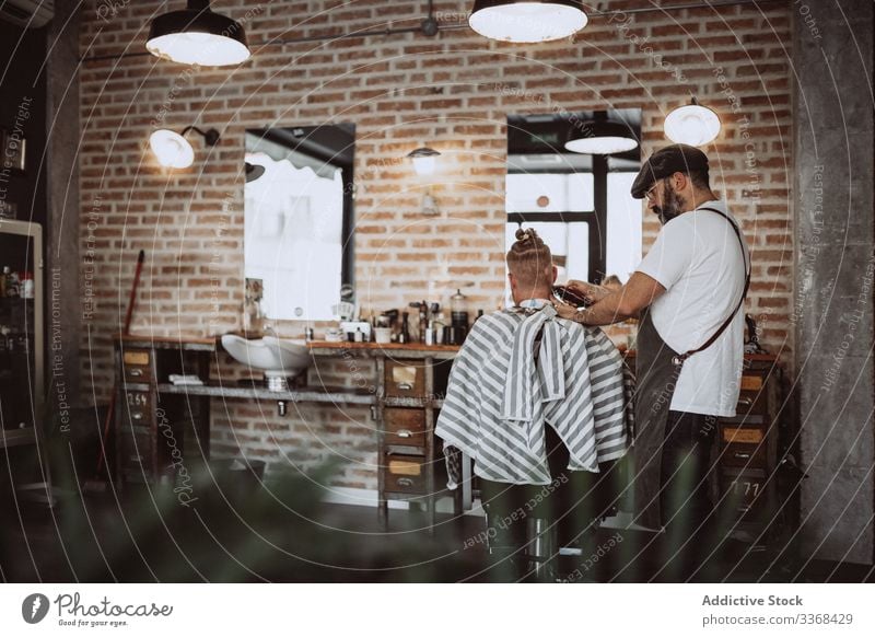 Hairdresser cutting a anonymous redhead man hair client trendy hairdresser barbershop bearded masculinity customer care salon hipster hairstylist handsome