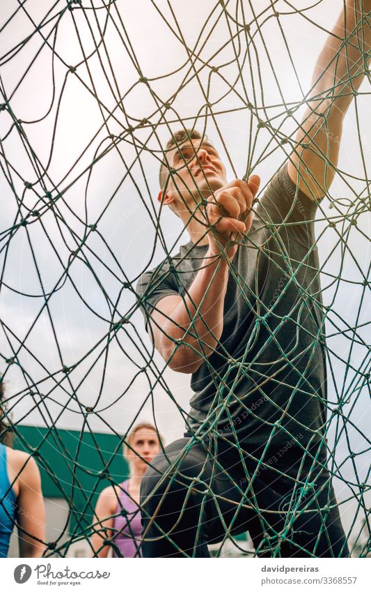 Male in obstacle course climbing net Lifestyle Sports Climbing Mountaineering Human being Man Adults Observe Authentic Strong Effort Competition view from below