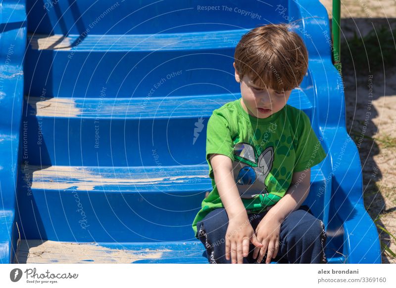 Brazilian boy sitting on toy stairs of playground. Outdoor play day. nature activity little adorable person brazilian green ethnic mixed small caucasian happy