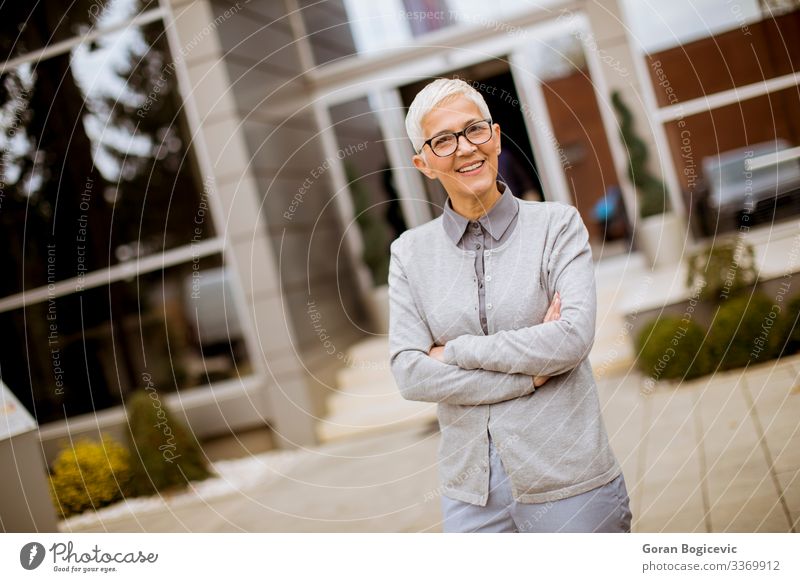 Outdoor portrait of happy cheerful senior businesswoman with crossed arms Lifestyle Happy Success Work and employment Office Business Company Human being Woman