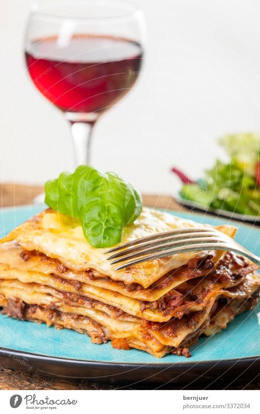 Lasagne on a blue plate Meat Cheese Nutrition Lunch Dinner Crockery Plate Restaurant Gastronomy Wood Fresh Blue Portion Baking Specialities Parmesan Wheat