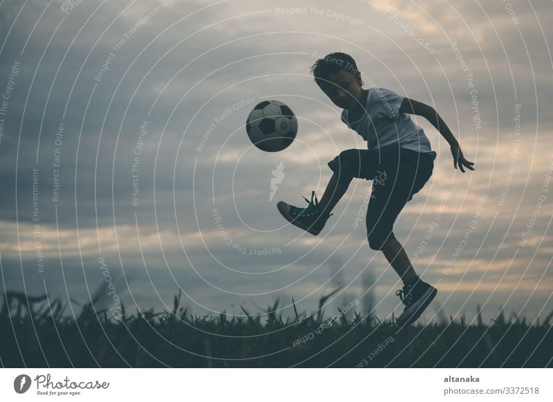 Young little boy playing in the field with soccer ball. Concept of sport. Lifestyle Joy Happy Relaxation Leisure and hobbies Playing Summer Sports Soccer Child