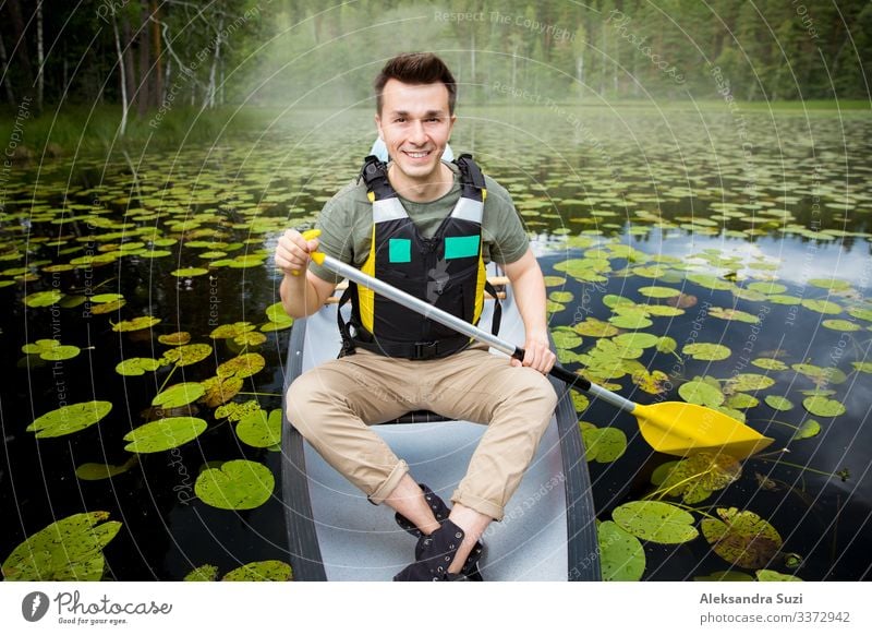 Two men in life vests canoeing in forest lake. Action Going Adventure candid Canoe Destination Discover Finland Forest Happy Lake Landscape Lifestyle Man Nature